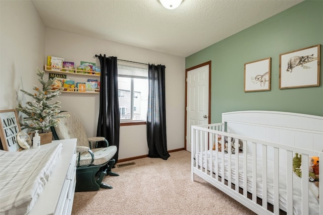 bedroom featuring a textured ceiling, light carpet, and a nursery area