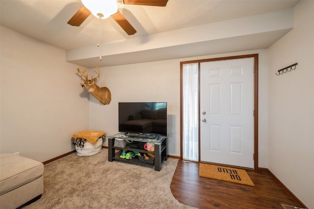 living room featuring ceiling fan, a textured ceiling, and hardwood / wood-style flooring