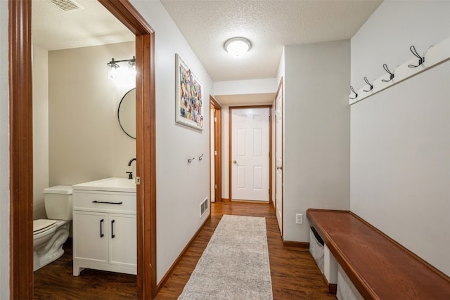 mudroom with a textured ceiling, sink, and dark hardwood / wood-style floors