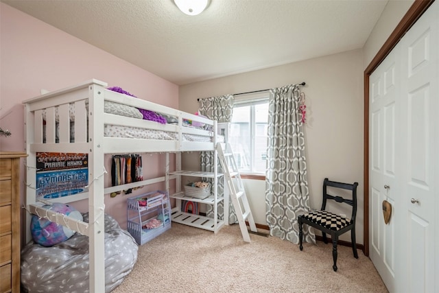 bedroom with carpet, a textured ceiling, and a closet