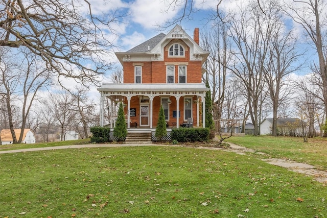 victorian-style house featuring covered porch and a front yard