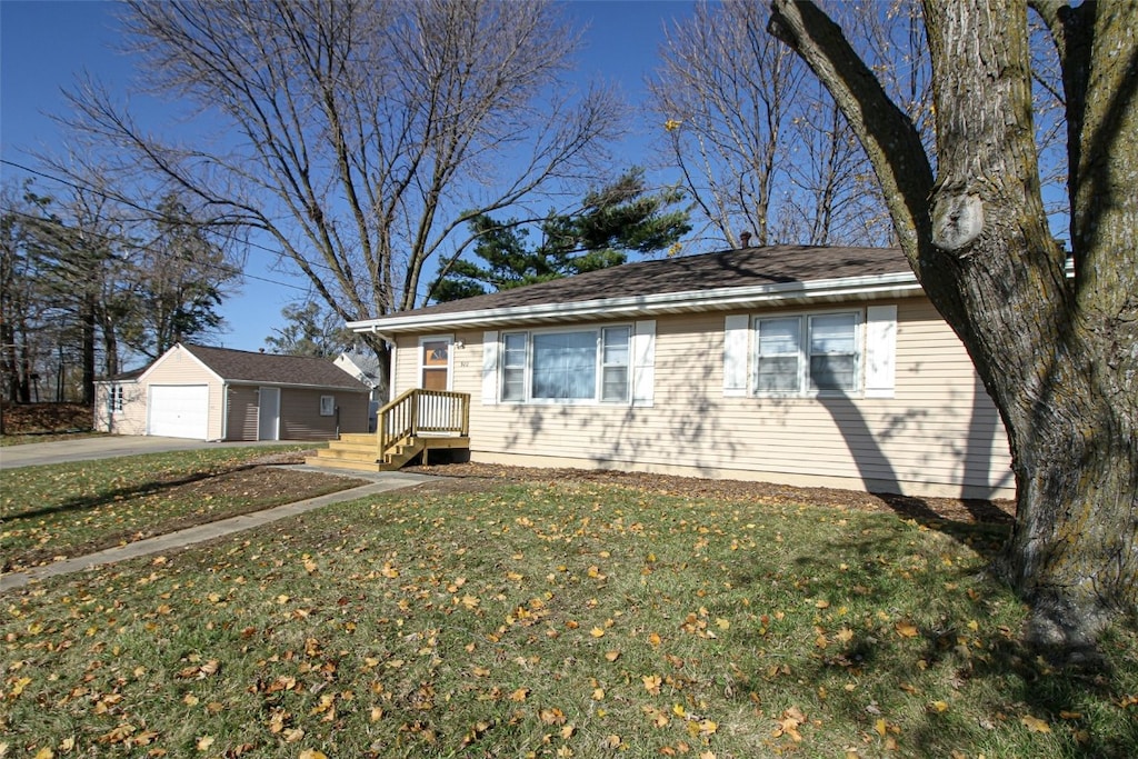 view of front of home with an outbuilding, a garage, and a front lawn