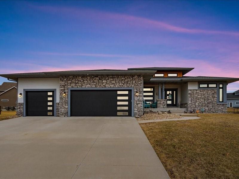 prairie-style home with a garage and a yard