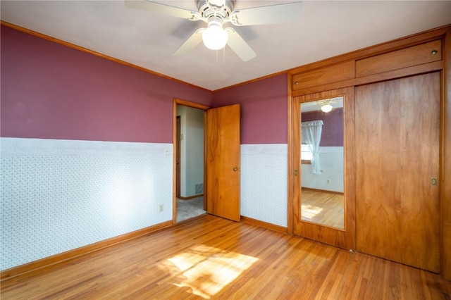 2482 65th St, Vinton, IA 52349 - unfurnished bedroom featuring light wood-style flooring, wainscoting, ornamental molding, ceiling fan, and baseboards