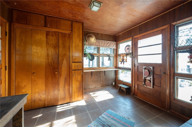 foyer entrance with wood ceiling and wood walls