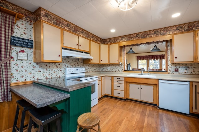 kitchen featuring sink, white appliances, and light hardwood / wood-style flooring