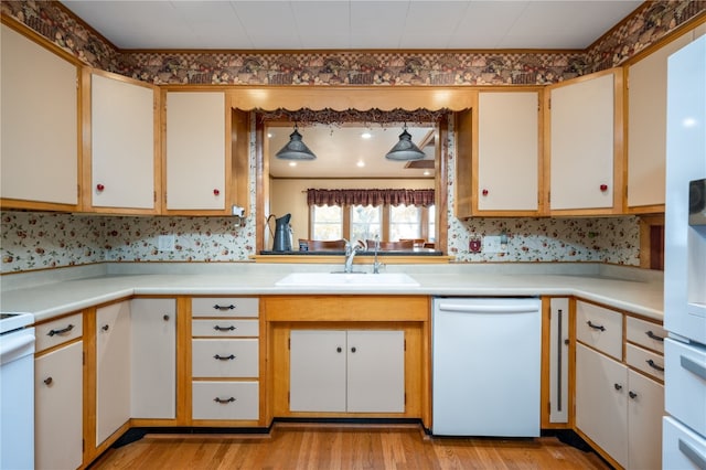 kitchen with light hardwood / wood-style flooring, white dishwasher, white cabinetry, and sink