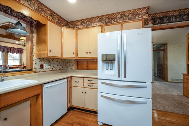 2482 65th St, Vinton, IA 52349 - kitchen featuring white appliances, light countertops, a sink, light wood-type flooring, and wallpapered walls