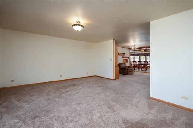 carpeted empty room with a notable chandelier