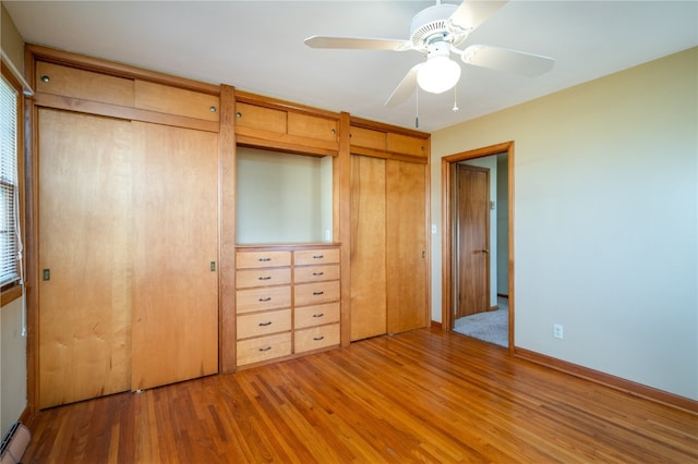 unfurnished bedroom featuring hardwood / wood-style flooring, ceiling fan, and a baseboard heating unit