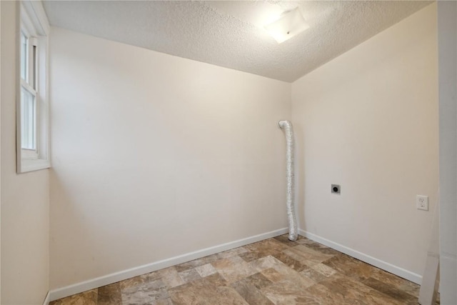 laundry room with hookup for an electric dryer and a textured ceiling