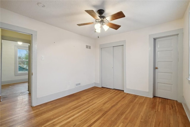 unfurnished bedroom featuring light hardwood / wood-style flooring, a closet, and ceiling fan