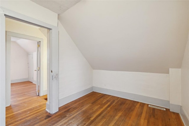 additional living space featuring hardwood / wood-style floors and vaulted ceiling