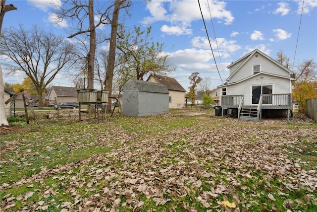 view of yard with a wooden deck and a storage unit