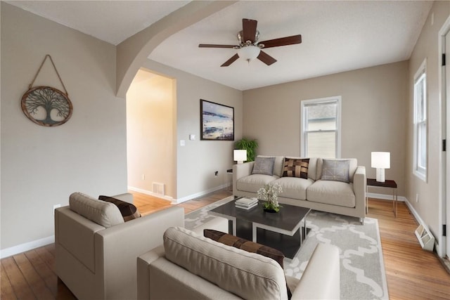 living room with light hardwood / wood-style flooring and ceiling fan