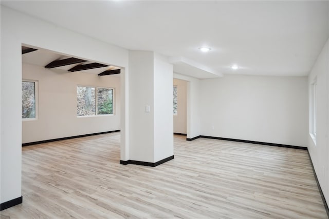 interior space featuring vaulted ceiling with beams and light hardwood / wood-style floors