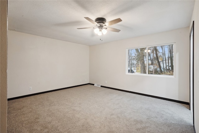 carpeted empty room featuring ceiling fan and a textured ceiling