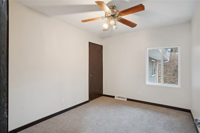 carpeted empty room featuring ceiling fan