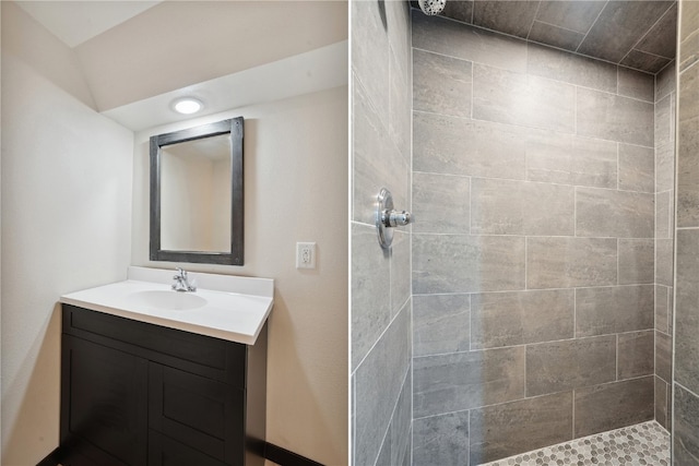 bathroom featuring tiled shower and vanity