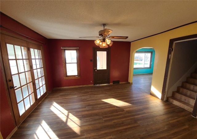 interior space featuring a textured ceiling, ceiling fan, a healthy amount of sunlight, and dark hardwood / wood-style floors