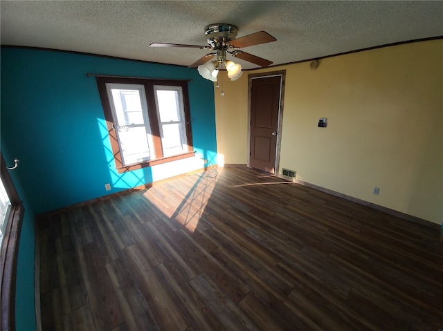 unfurnished room with a textured ceiling, dark hardwood / wood-style floors, and ceiling fan