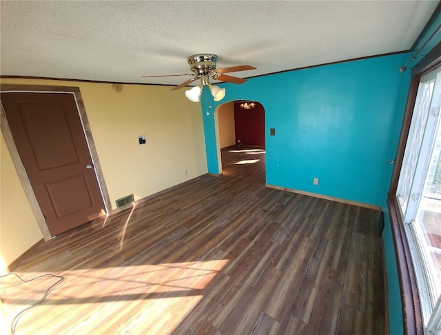 empty room with a textured ceiling, dark hardwood / wood-style flooring, and ceiling fan