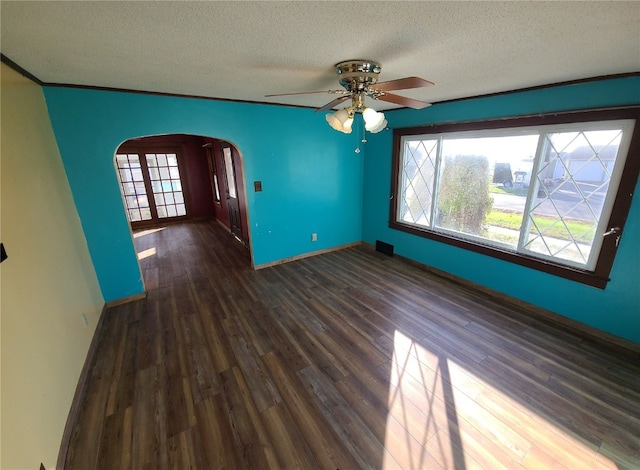 unfurnished room featuring a textured ceiling, dark hardwood / wood-style flooring, ceiling fan, and crown molding