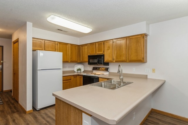 kitchen featuring kitchen peninsula, sink, dark hardwood / wood-style floors, and white appliances