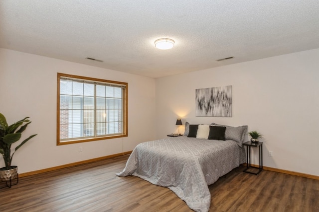 bedroom featuring hardwood / wood-style floors and a textured ceiling