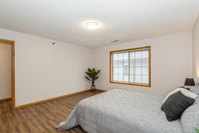 bedroom with a textured ceiling and hardwood / wood-style flooring