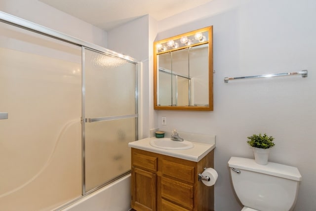 full bathroom featuring combined bath / shower with glass door, toilet, and vanity