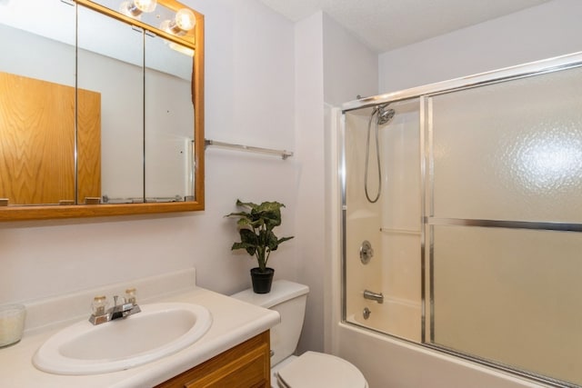 full bathroom featuring shower / bath combination with glass door, vanity, a textured ceiling, and toilet