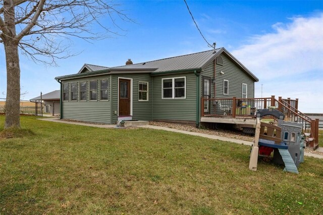 back of house with a deck and a lawn