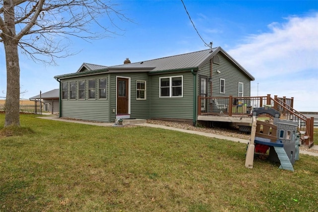 rear view of property featuring a yard and a deck