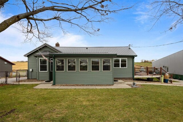 rear view of house featuring a lawn and a wooden deck