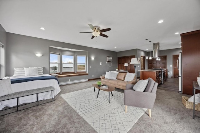 carpeted living room featuring a baseboard heating unit and ceiling fan