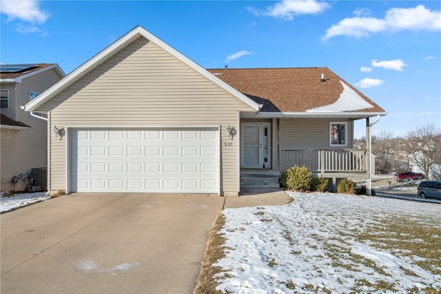 view of front of home with covered porch, a garage, and central AC