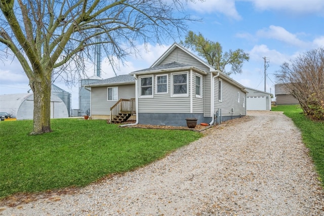 bungalow featuring a front lawn, an outdoor structure, and a garage