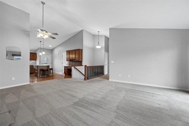 unfurnished living room with carpet, high vaulted ceiling, and ceiling fan