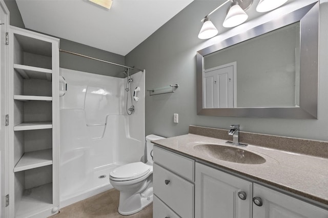 bathroom with tile patterned floors, toilet, vanity, and walk in shower