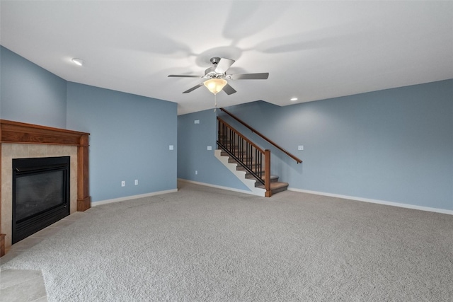 unfurnished living room with light carpet, ceiling fan, and a tiled fireplace