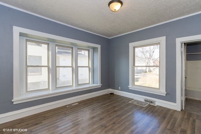 unfurnished room featuring dark wood-type flooring, a textured ceiling, and ornamental molding