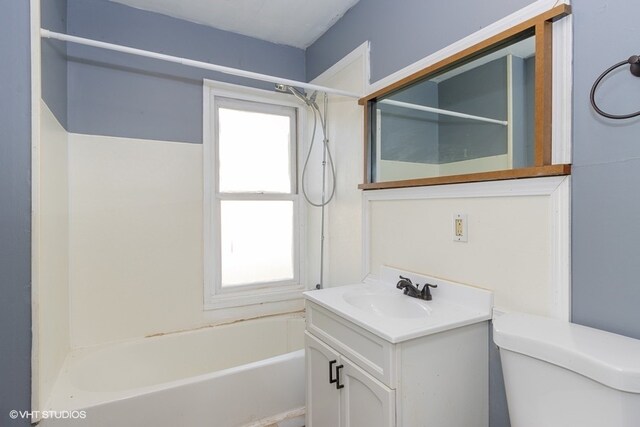 full bathroom featuring vanity, a healthy amount of sunlight, toilet, and bathing tub / shower combination