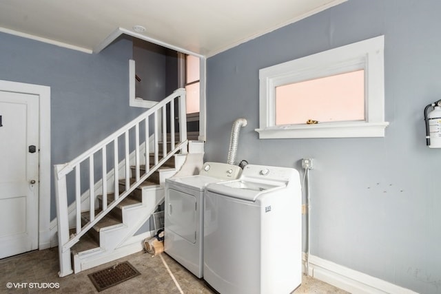 washroom with separate washer and dryer and ornamental molding