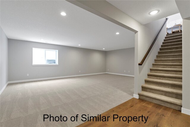 basement featuring hardwood / wood-style floors and a textured ceiling