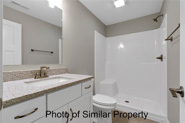 bathroom with a shower, vanity, toilet, and tile patterned flooring