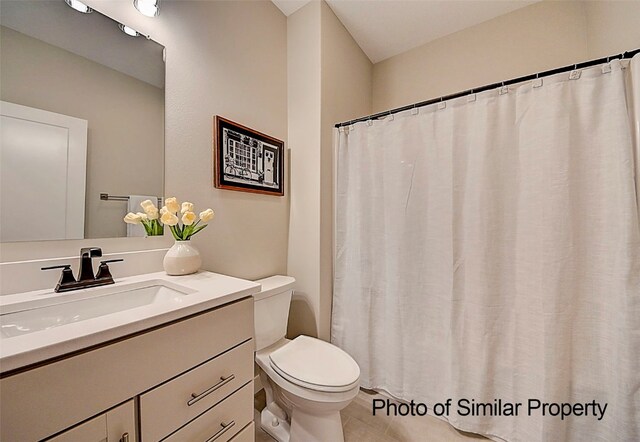 bathroom with tile patterned flooring, vanity, and toilet