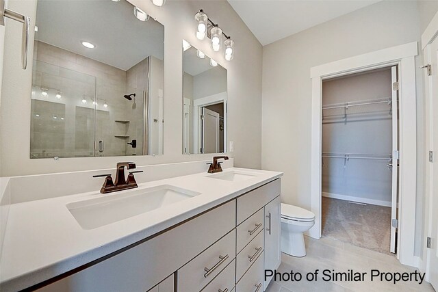 bathroom with tile patterned floors, vanity, toilet, and a shower with door