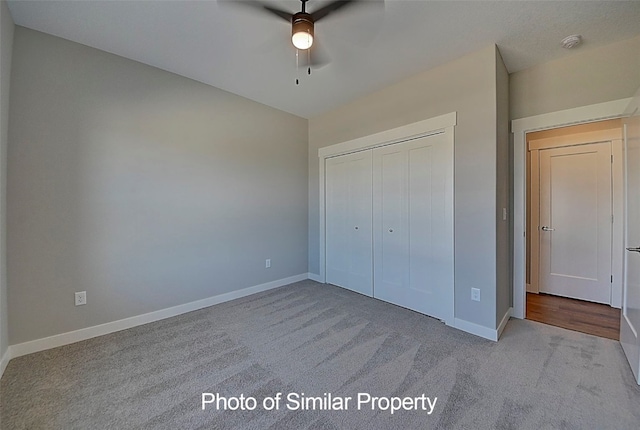 unfurnished bedroom featuring ceiling fan, a closet, and light carpet