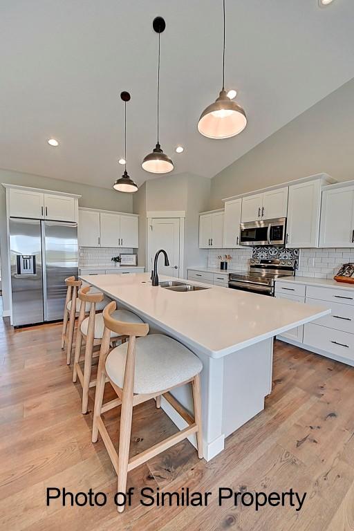 2933 Clubhouse Dr, Marion, IA 52302 - kitchen featuring stainless steel appliances, decorative backsplash, white cabinetry, recessed lighting, and vaulted ceiling